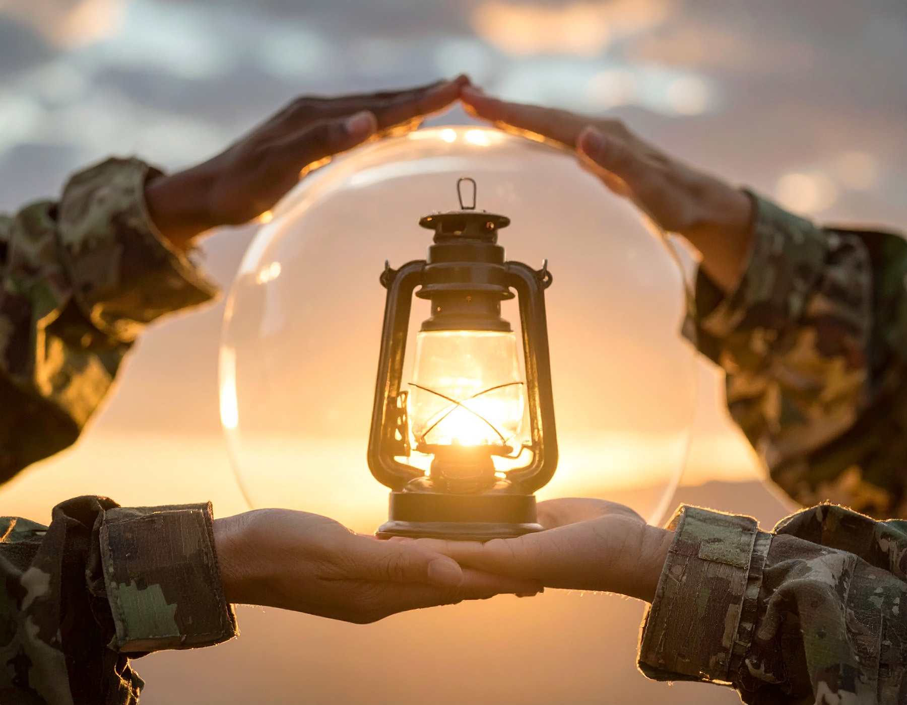 Many hands holding a lantern