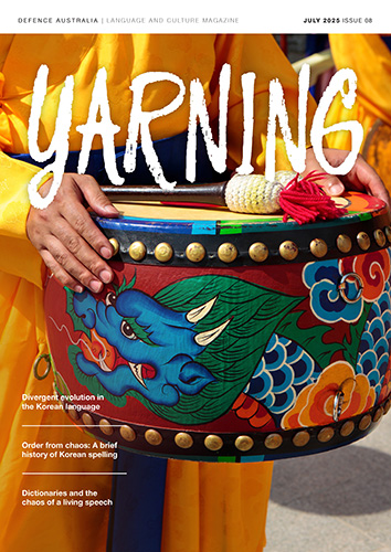 Yarning Magazine Cover Kuly 2025 - Yellow robed person hold a dragaon decorated drum