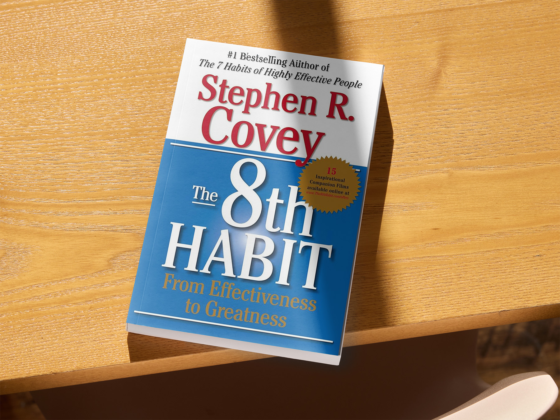 The 8th Habit book cover, the book is lying on a table 