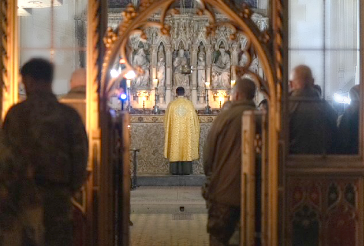 Evening Prayer, A priest stand facing the alter with uniformed soldiers in the congregation