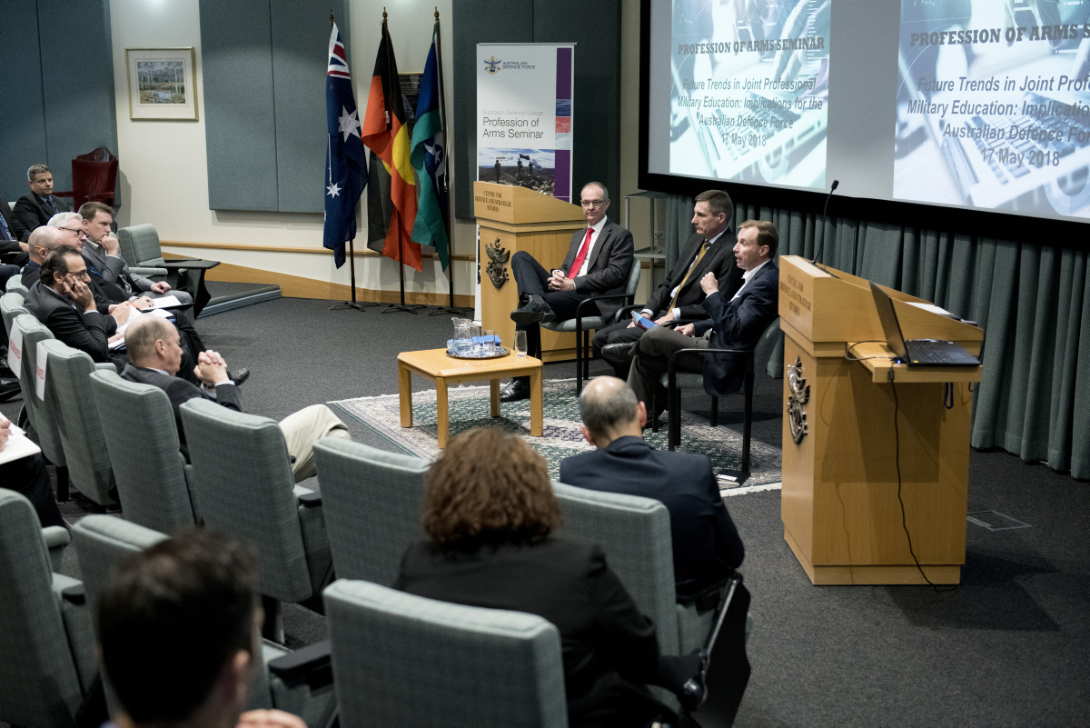 Australian Defence members sitting in a theatre giving a presentation on the restructure of the Australian Defence College.