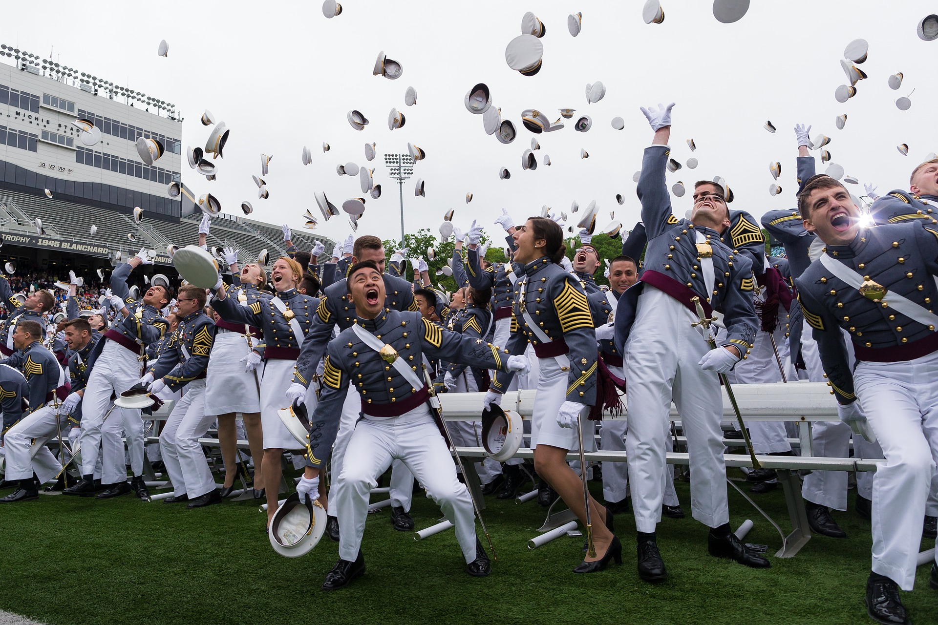 Military college graduates celebrating and throwing caps in the air