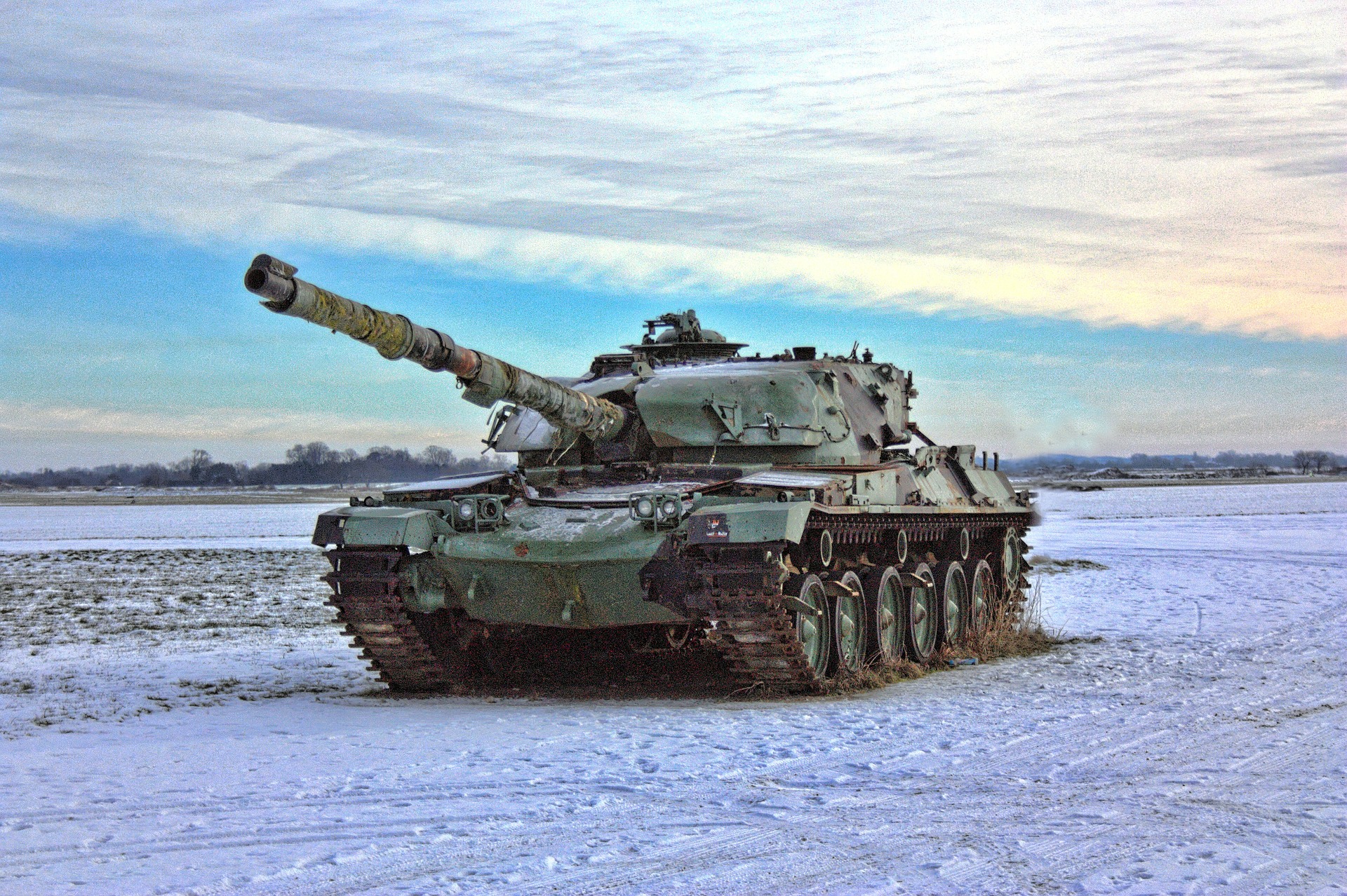 Army tank rolling along a snowy field