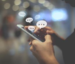 A person entering a comment on a mobile device.