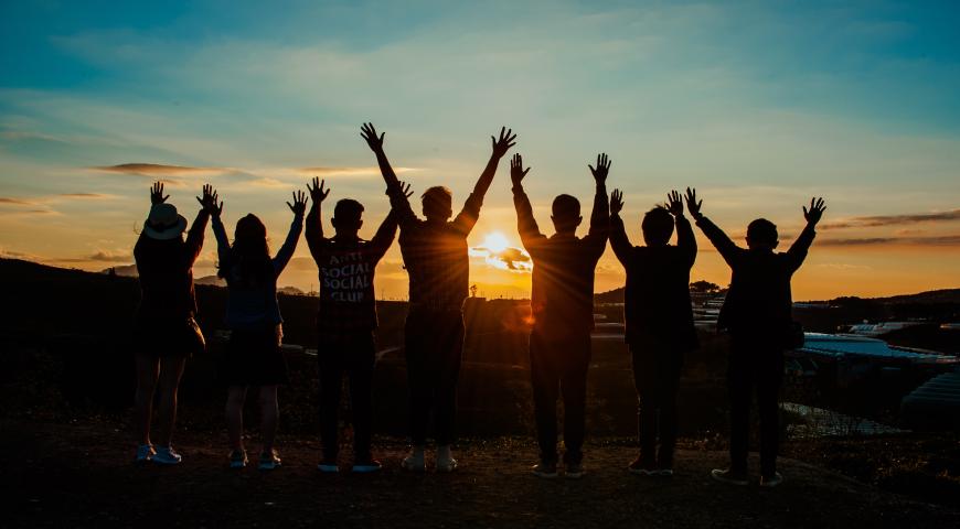 Group of people holding hands in the air