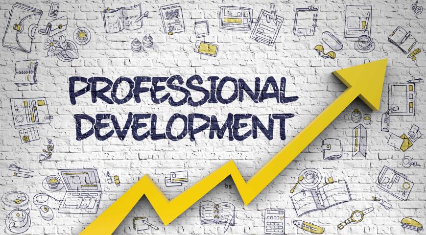 Professional development written on a white brick wall with a yellow arrow pointing upward