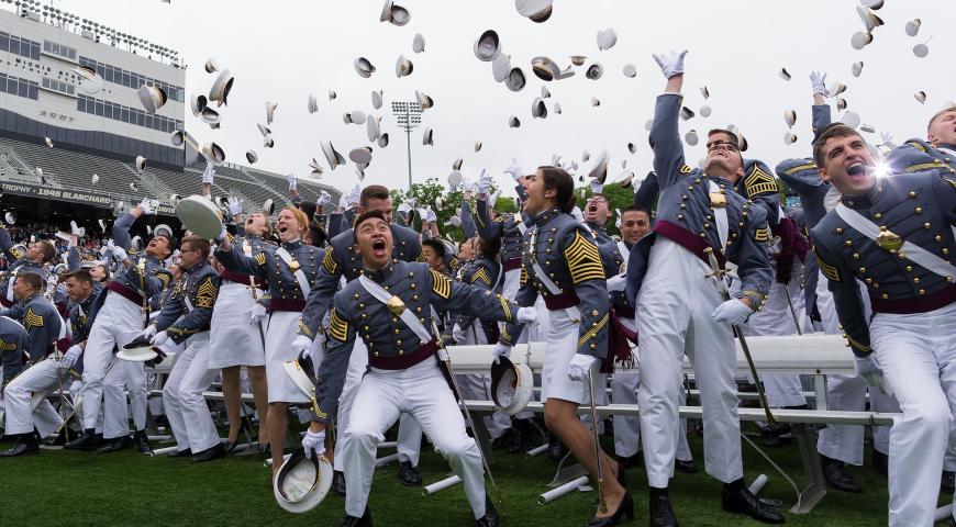 Military college graduates celebrating and throwing caps in the air