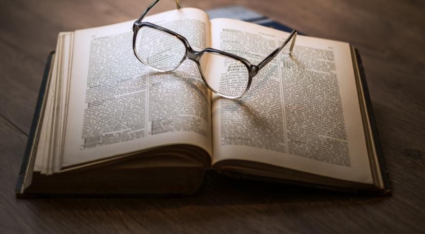 Open book with spectacles on top