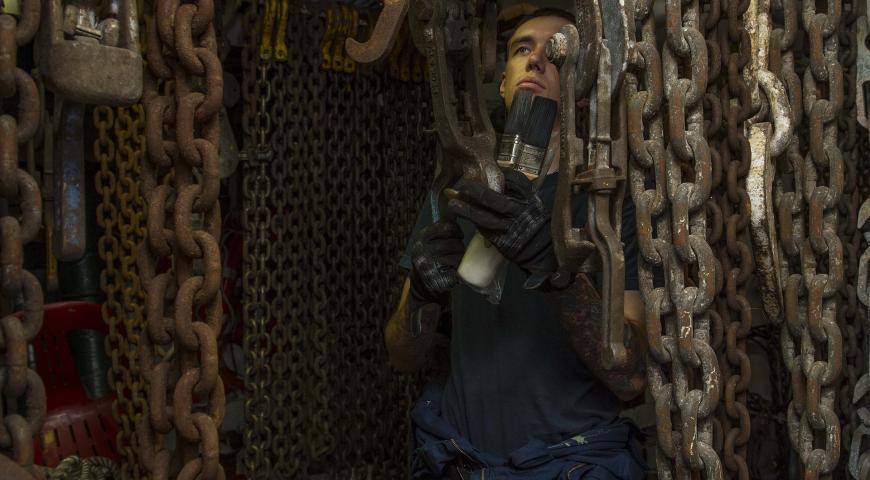 A person performing maintenance on a ship