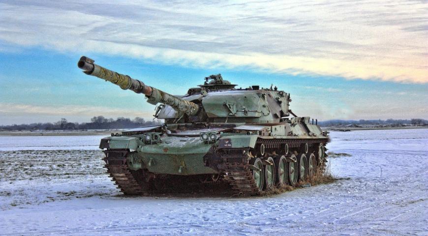 Army tank rolling along a snowy field