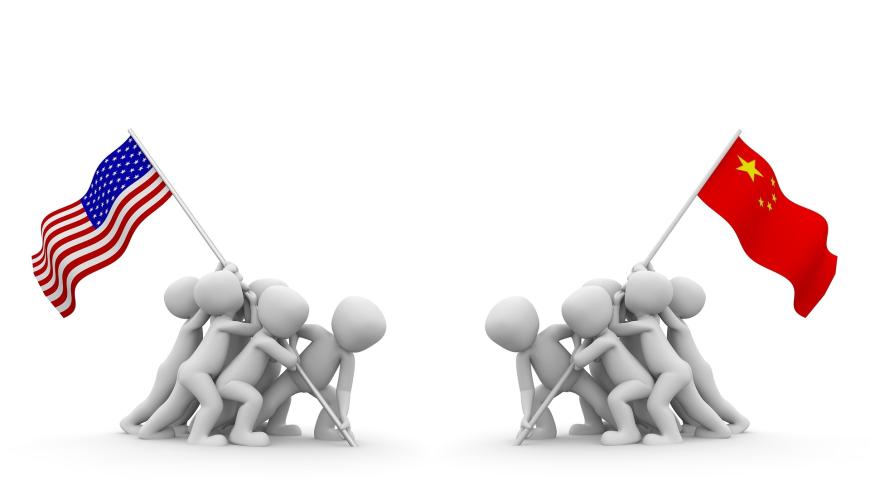 Two groups of people facing off against each other, one holding a US flag and one holding a Chinese flag