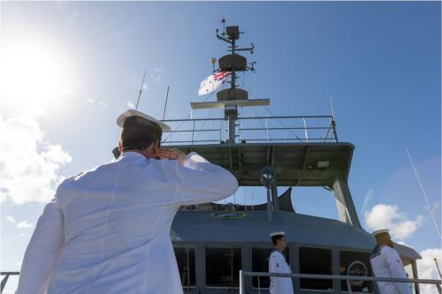 Commanding Officer HMAS Benalla salutes the Australian White Ensign as it is lowered for the last time during the ships' decommissioning ceremony held at HMAS Cairns on 16 June 2023