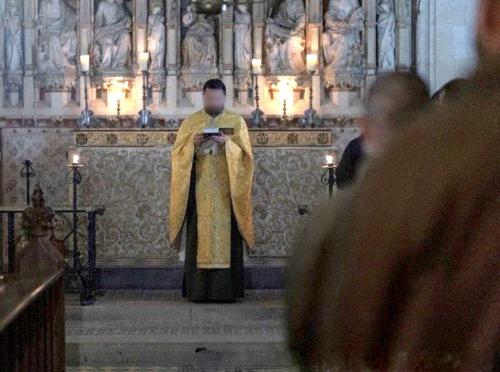 Evening Prayer Service - a Priest holding the bible preaching to a congregation of uniformed soldiers