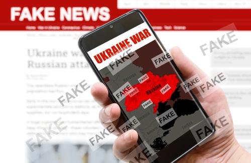 MObile phone showing a map of the Ukraine. It is covered repeatedly with the word 'Fake' 